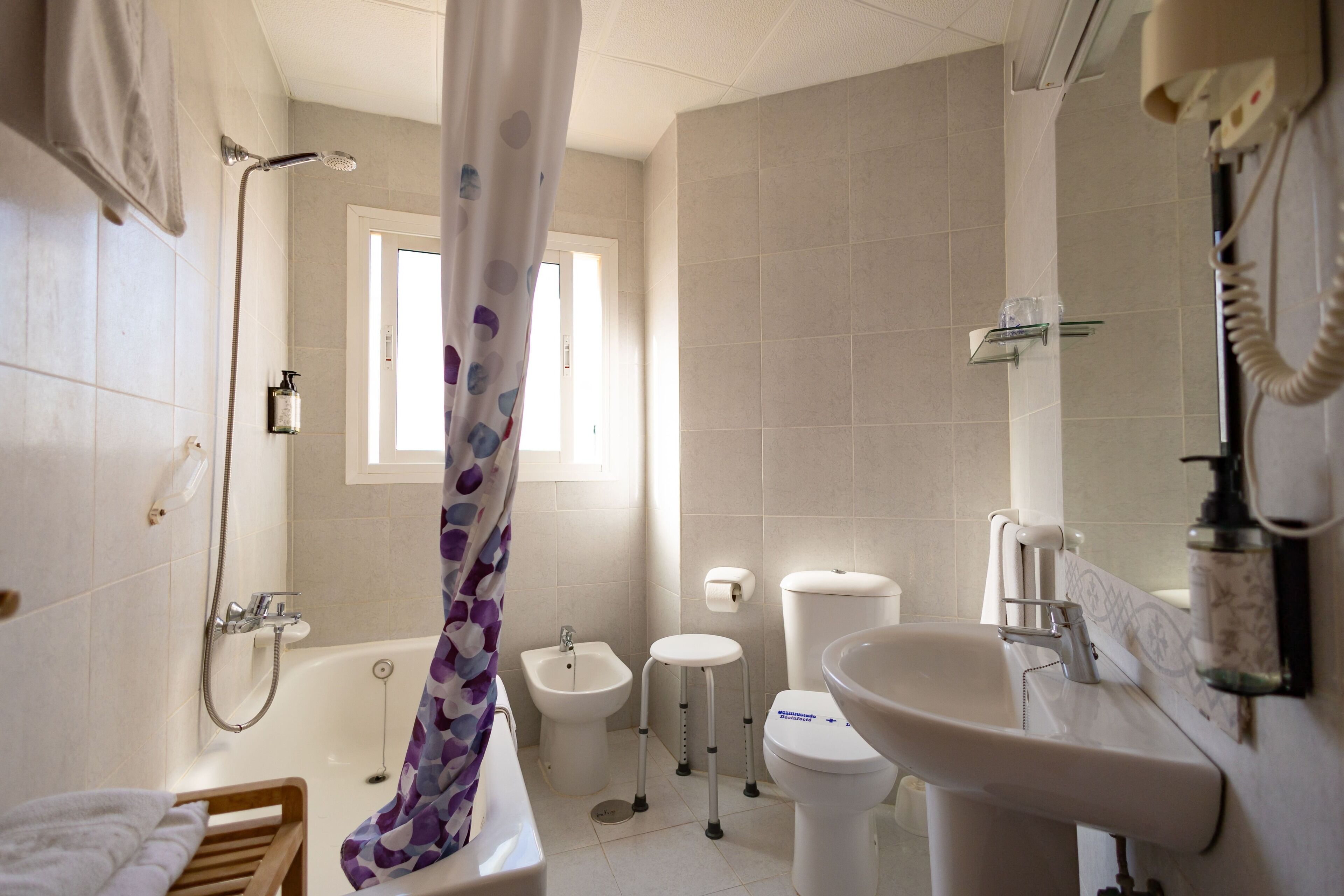 Un baño con bañera, inodoro, bidé y lavamanos.