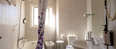 Ein Badezimmer mit Badewanne, Toilette, Bidet und Waschbecken.