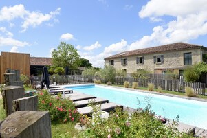 Una piscina al aire libre, sillones reclinables de piscina