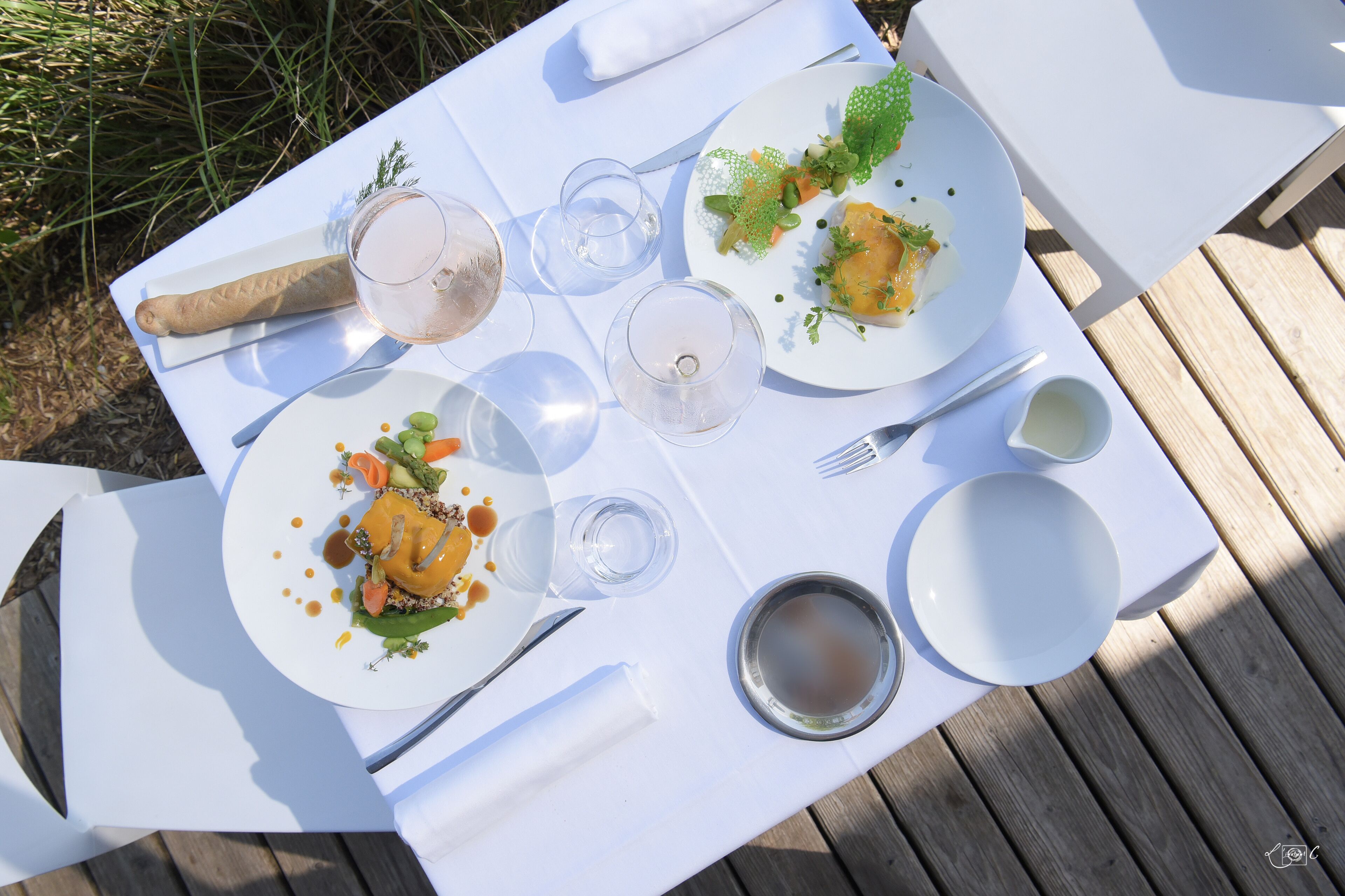 A table set for a meal with plates, cutlery, and glasses.