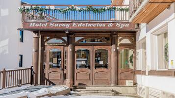 L'ingresso di un hotel con un cartello che riporta 'Hotel Savoy Edelweiss & Spa'.