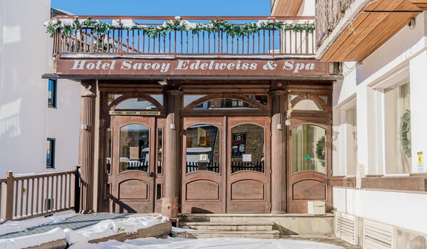 Entrada de un hotel con un cartel que dice 'Hotel Savoy Edelweiss & Spa'.