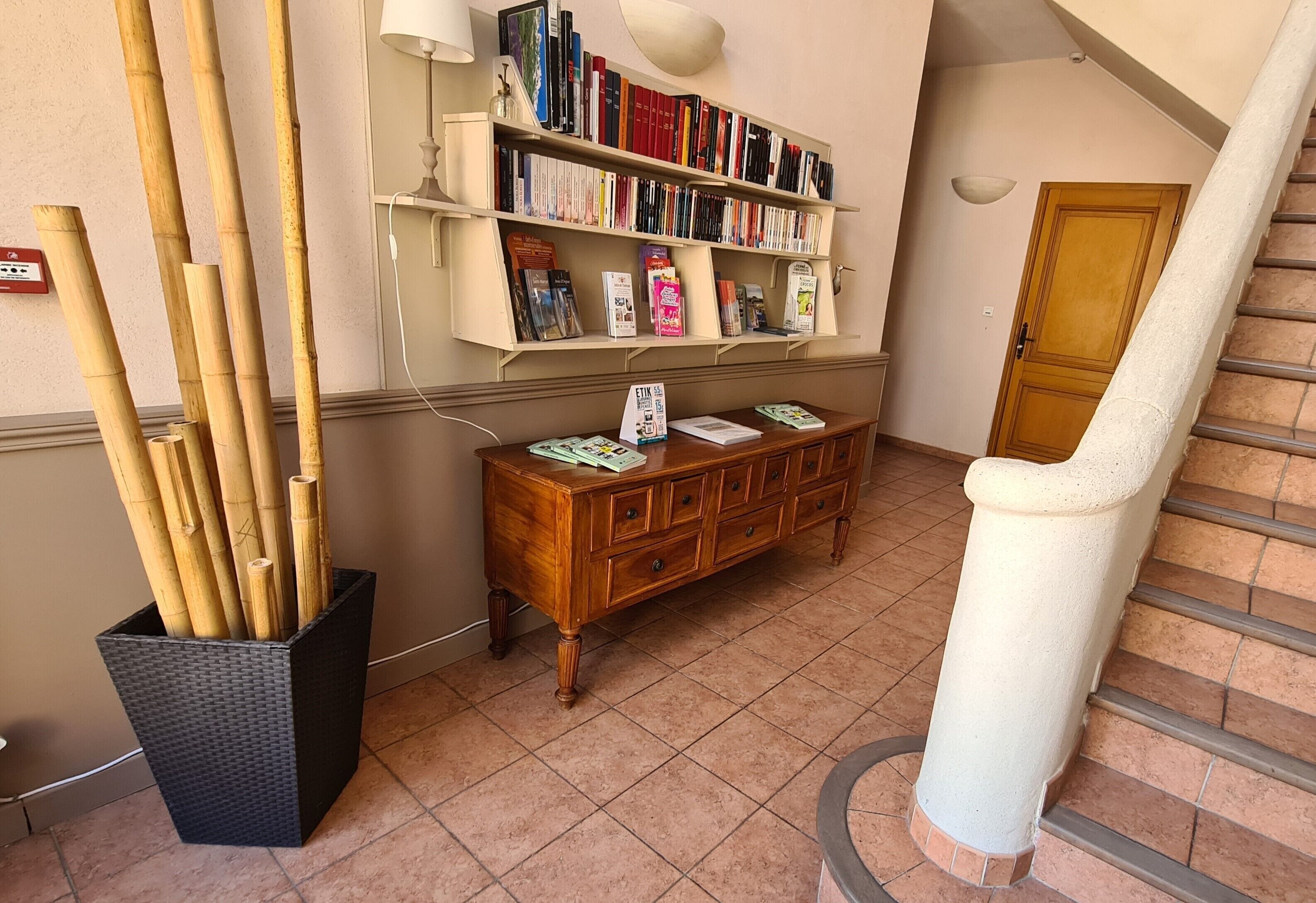 Un corridoio con una libreria, un armadio in legno e una scala.
