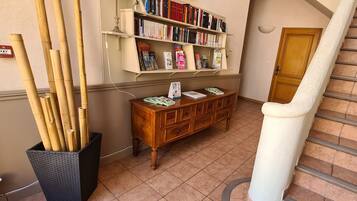Un corridoio con una libreria, un armadio in legno e una scala.