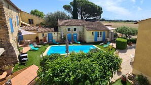 A villa with a swimming pool, outdoor seating, and a well-maintained garden. - Logis Hotel La Bastide St Bach (Suze-la-Rousse)