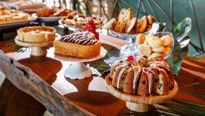 A buffet with various desserts including cakes, pastries, and a bundt cake.