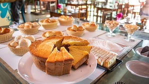 A variety of baked goods displayed on a table in a restaurant setting. - Pousada Rigatoni Beach (Porto Seguro)