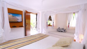 A bedroom with a bed, a television mounted on the wall, and a window with curtains. - Pousada Rigatoni Beach (Porto Seguro)