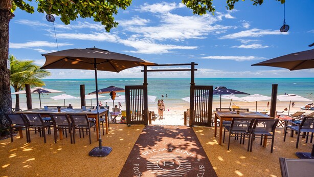 A beachside restaurant with outdoor seating, umbrellas, and a view of the ocean. - Pousada Rigatoni Beach (Porto Seguro)