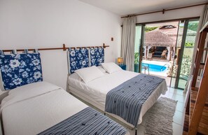 A bedroom with two beds, a large window, and a view of an outdoor pool area. - Pousada Rigatoni Beach (Porto Seguro)