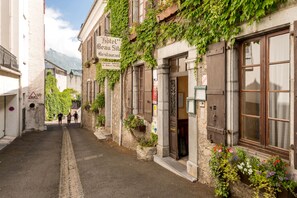 Una calle estrecha flanqueada por edificios, incluyendo un hotel con un letrero que indica que es restaurante.