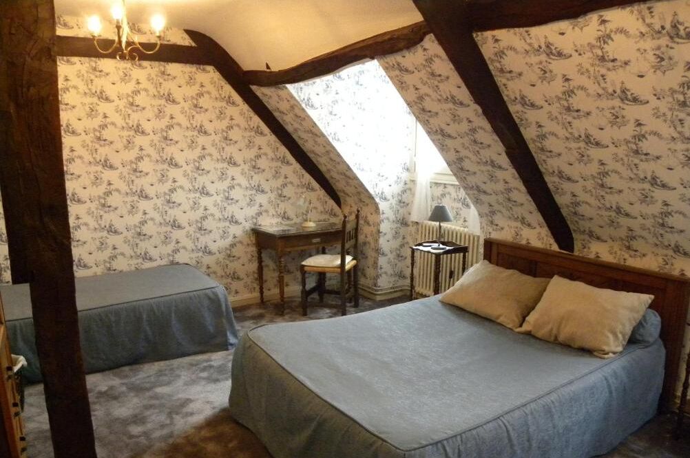 Une chambre avec deux lits, un bureau et une chaise.