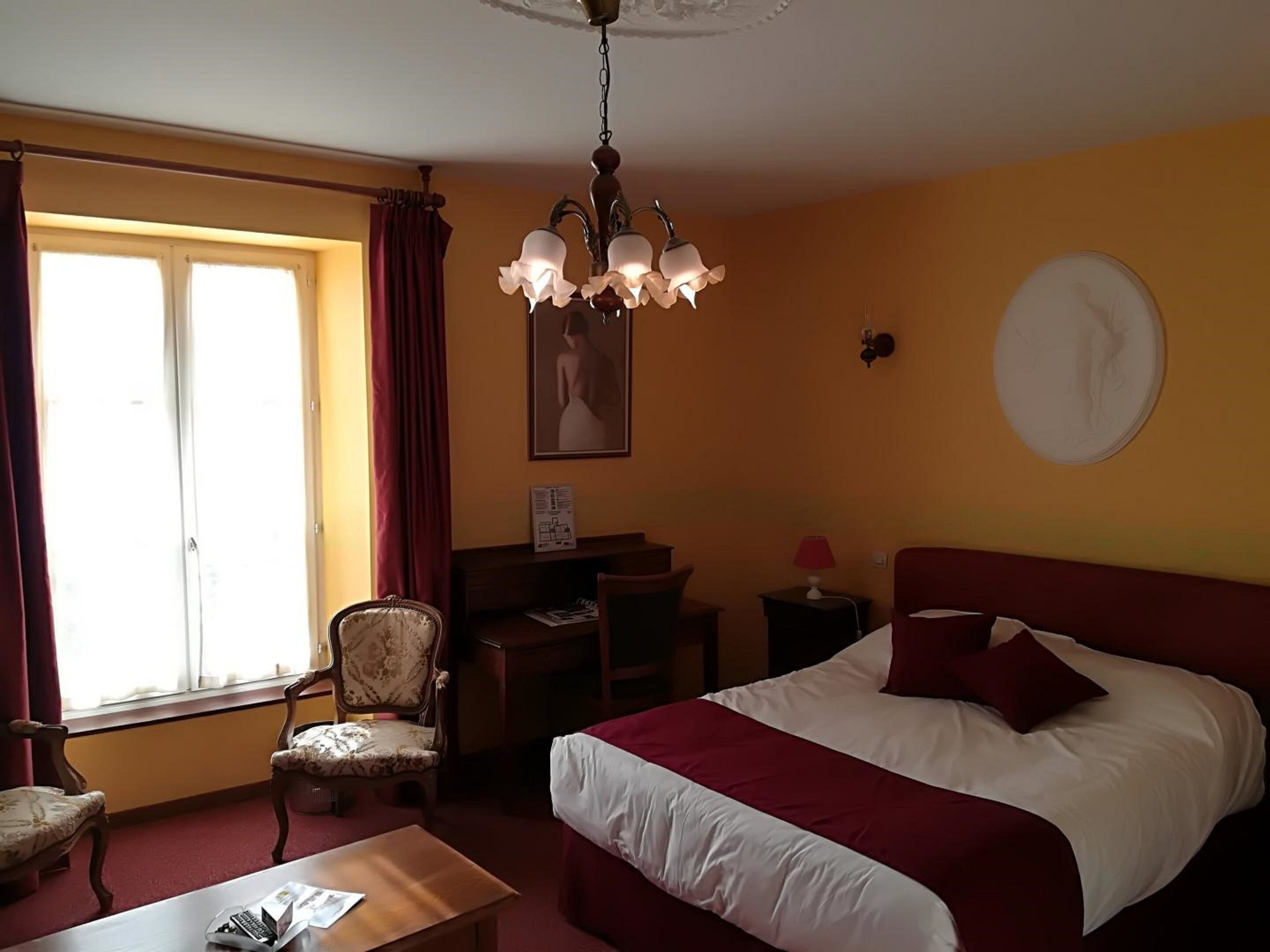 Ein Hotelzimmer mit Bett, Schreibtisch, Stuhl und Tisch.