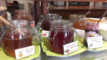 A display of various jams and jellies with labels indicating their names and ingredients.