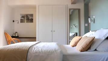 A bedroom with a bed, a chair, a wardrobe, and a mirror.