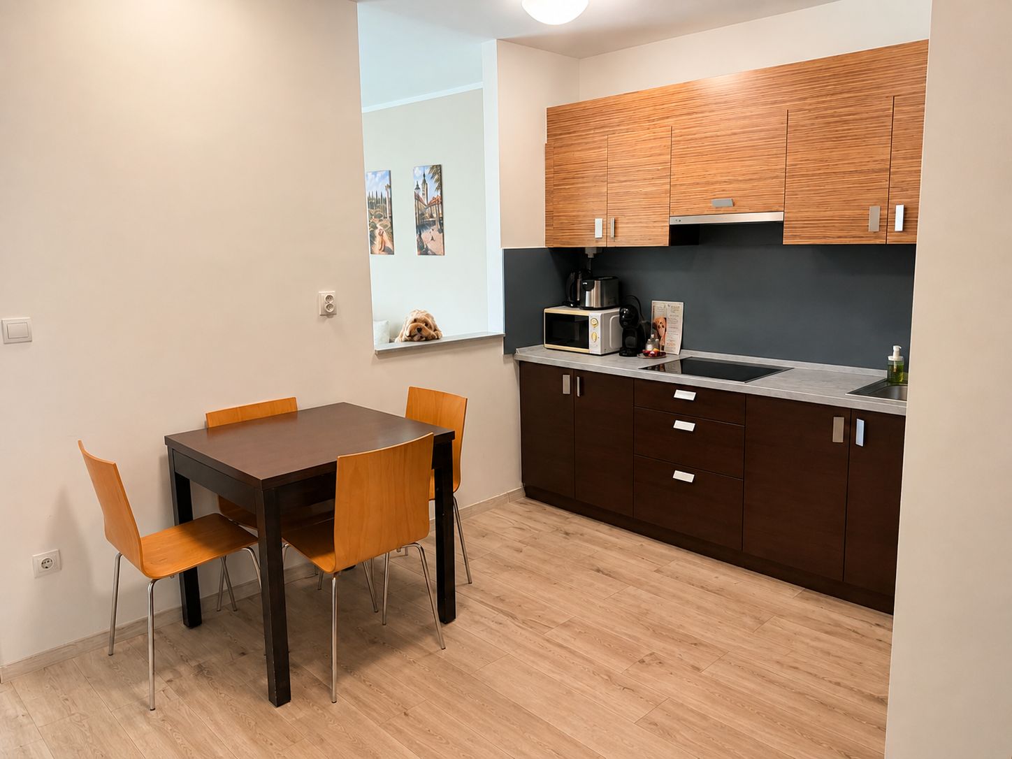 Une cuisine de taille réduite, avec des meubles de rangement en bois, un four à micro-ondes et un évier.