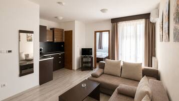 Een modern appartement met een woonruimte, kitchenette en een slaapkamer met uitzicht.
