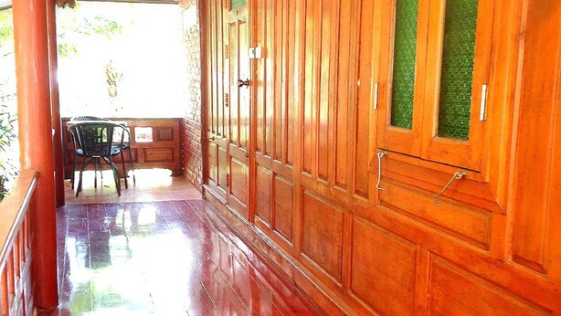 A corridor with wooden paneling and a polished red floor.