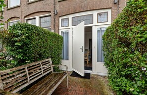 A residential building with a front door open, revealing a room with a chair and a small table. - Hotel Bor Scheveningen (The Hague)