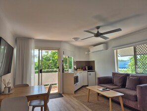Una sala moderna con un sofá, una mesa de centro y un comedor con mesa y sillas.