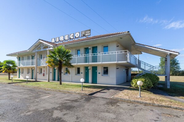 A two-story motel with a balcony and a sign that reads "AIRRECO".