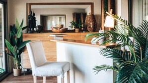 A modern hotel lobby with a wooden reception desk, a white cushioned chair, and potted plants. - Cannes Villa St Barth (Cannes)