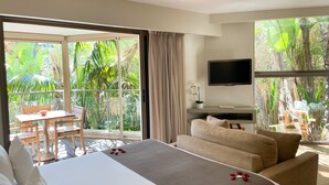 A hotel room with a bed, a sofa, a TV, and a balcony with a table and chairs. - Cannes Villa St Barth (Cannes)