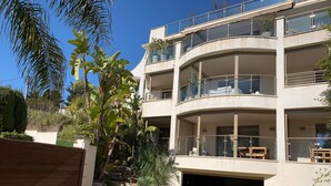 A multi-story residential building with balconies, a garage, and surrounding greenery. - Cannes Villa St Barth (Cannes)