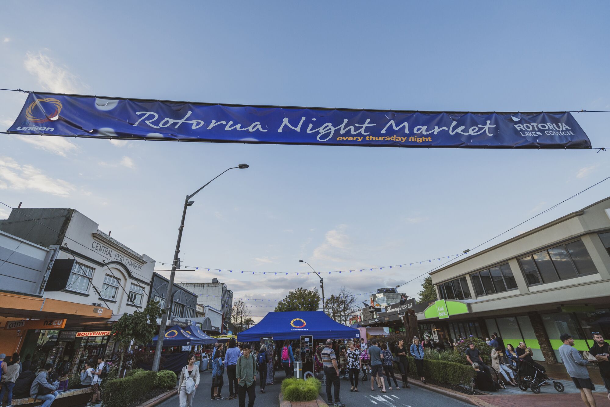 Una calle con un cartel anunciando el Mercado Nocturno Rotura.
