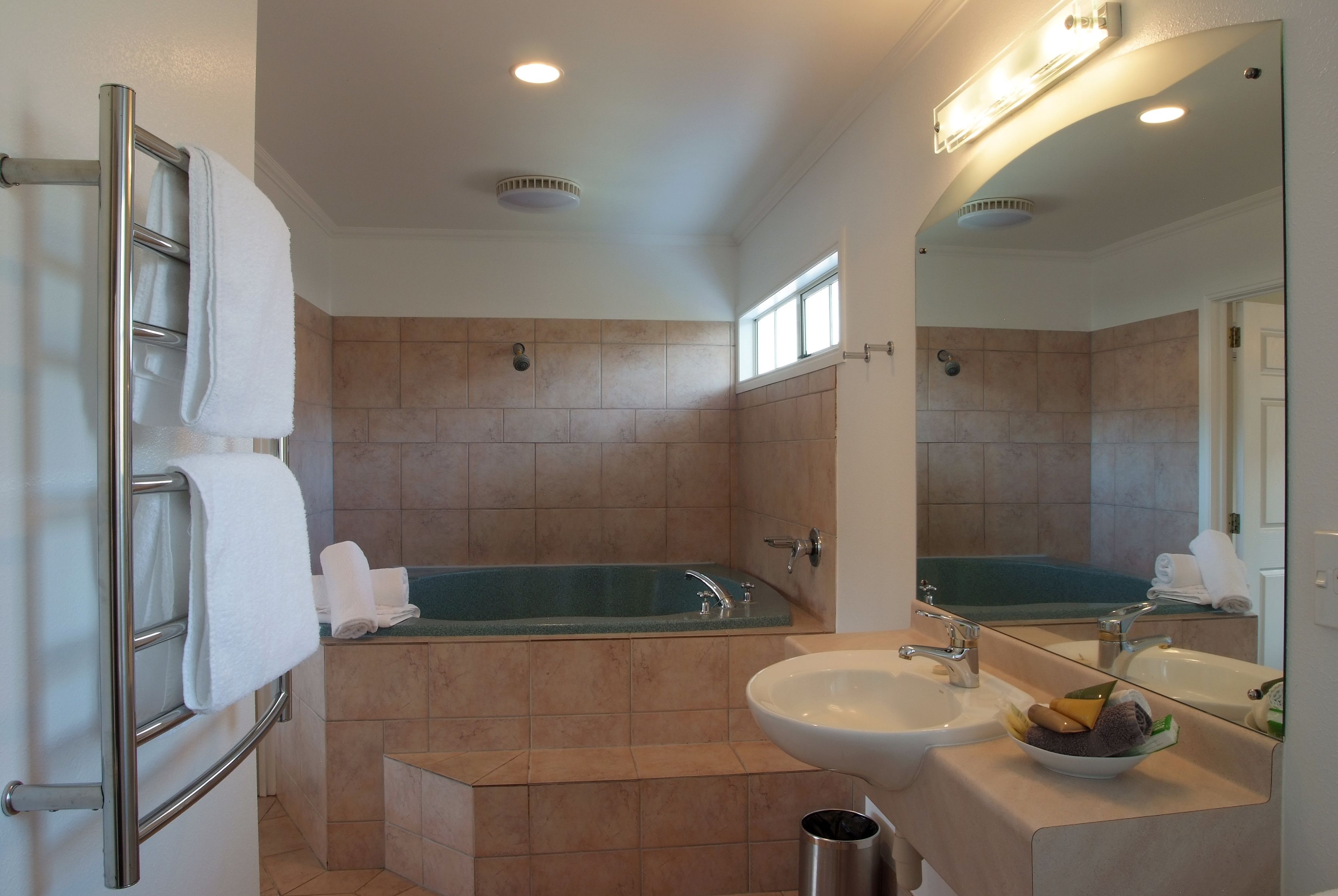 Une salle de bain avec une baignoire, un lavabo et un miroir.