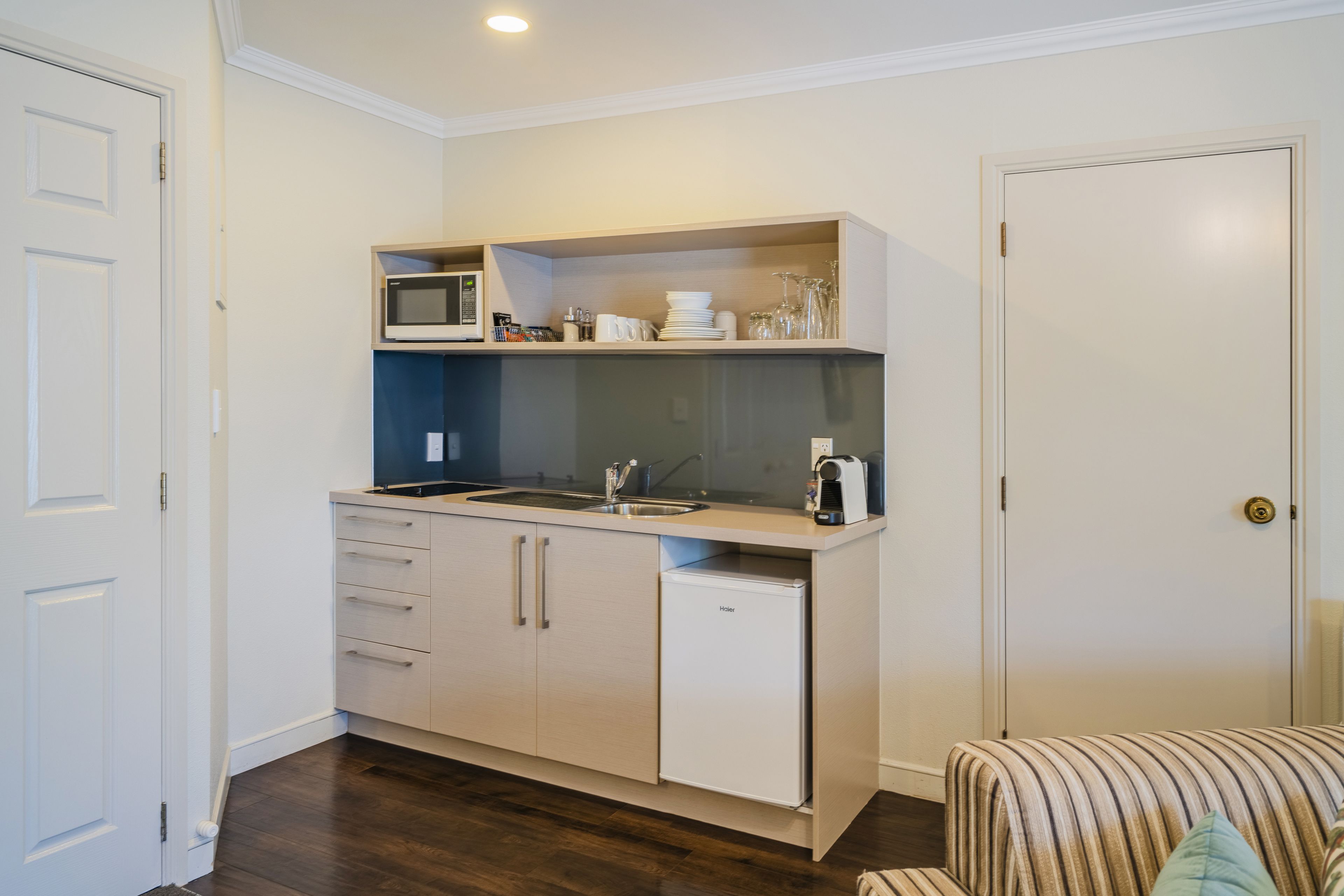 A compact kitchen with a microwave, sink, and refrigerator.