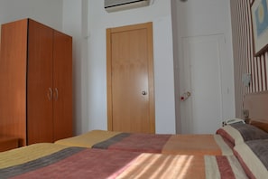 Un dormitorio con dos camas, un armario y una puerta.