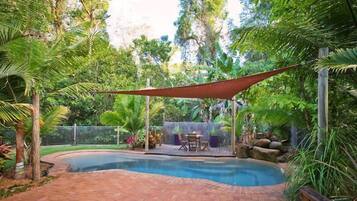 Alberca al aire libre y camastros