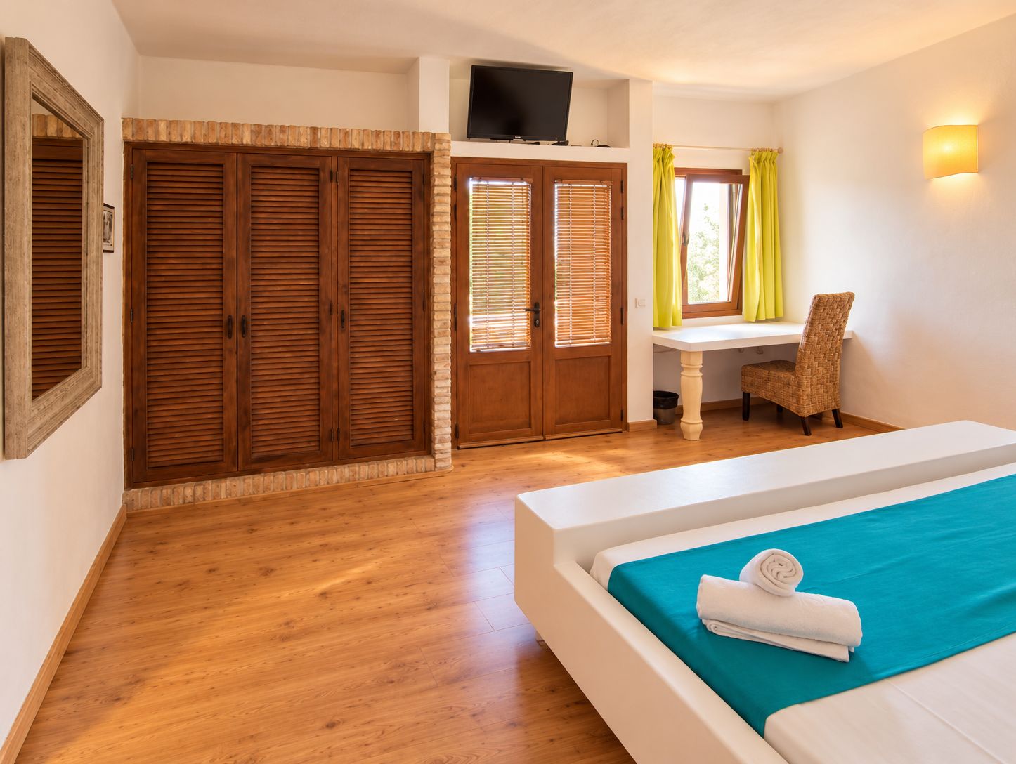 A bedroom with a bed, a desk, and a chair.