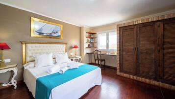 Une chambre d’hôtel avec un grand lit, un bureau, une chaise et une armoire.