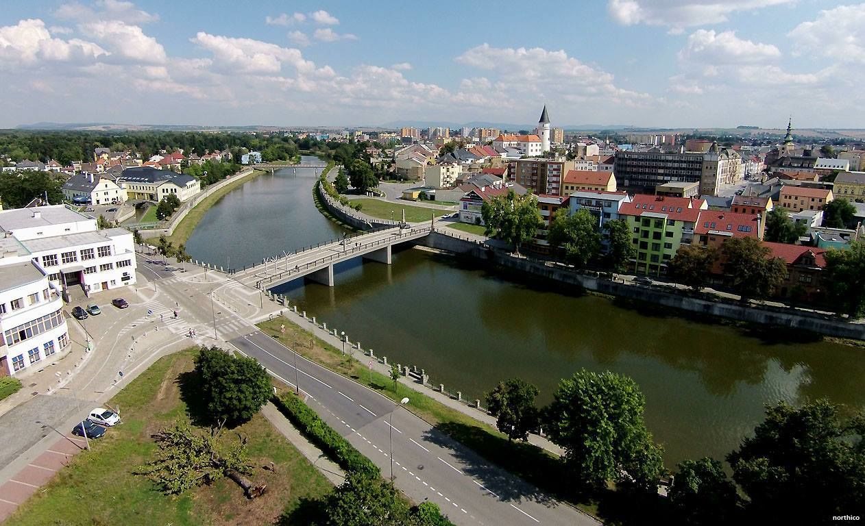A river with a bridge, buildings, and a road.