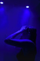 Una persona en una habitación con poca luz y iluminación azul.