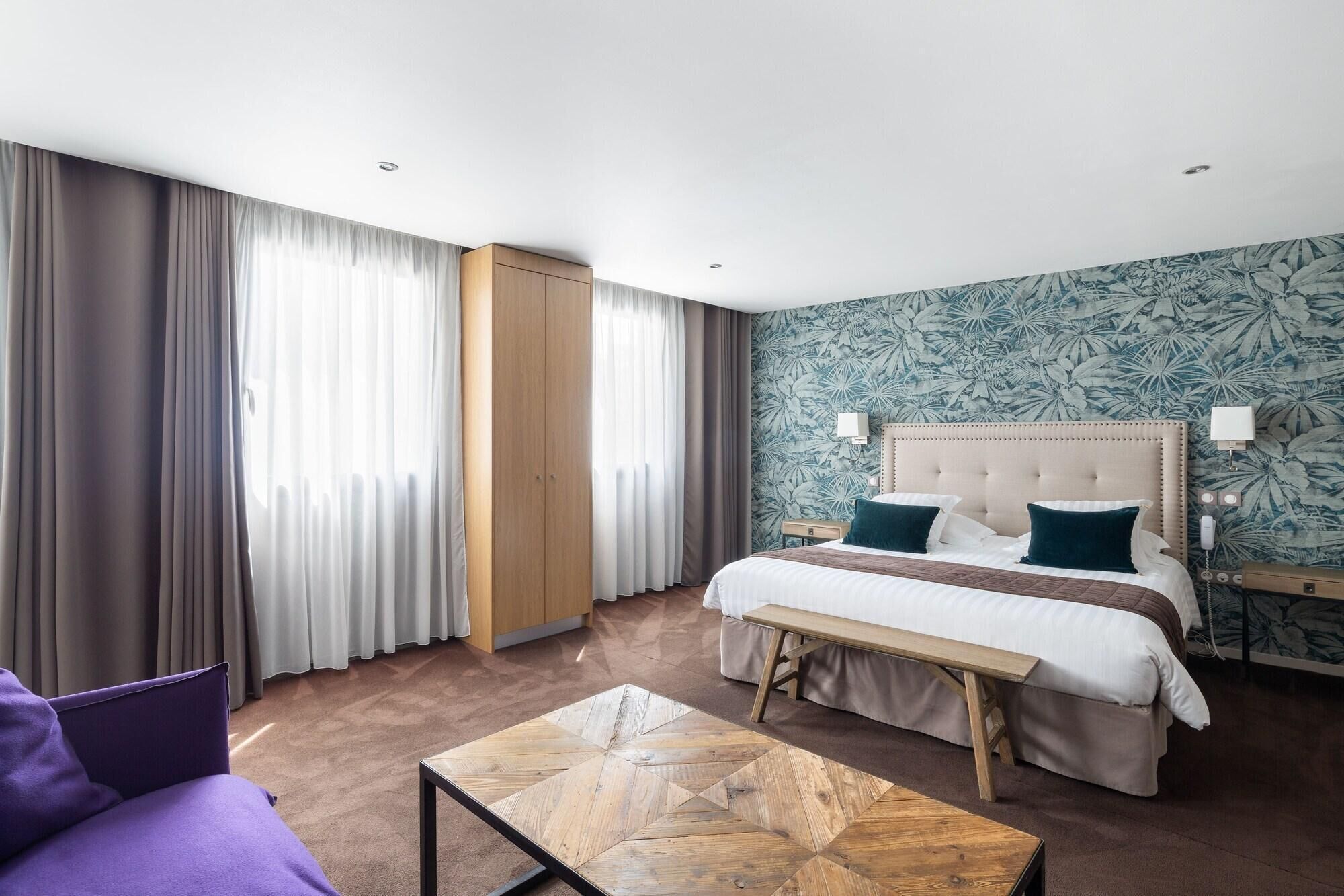A hotel room with a bed, bedside table, and a view of the outdoors.