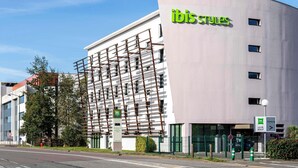 A modern building with the 'ibis styles' logo, a parking sign, and a sign indicating 'la chambre de la vie.' - ibis Styles Rennes Cesson (Cesson-Sevigne)