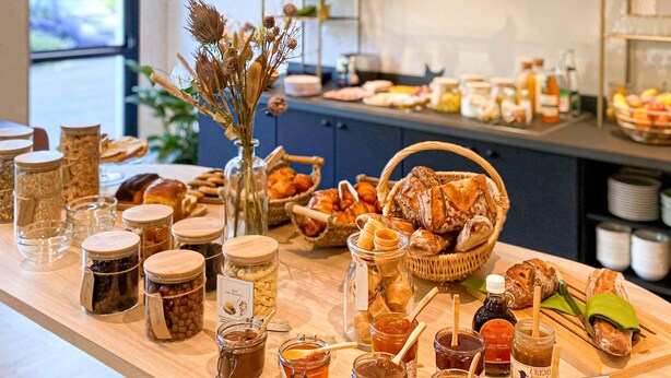 A buffet table with various food items and condiments. - ibis Styles Rennes Cesson (Cesson-Sevigne)