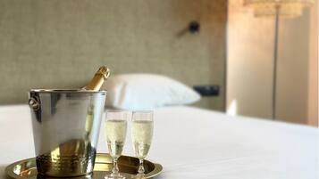 A minibar with a bottle of champagne and two glasses on a tray.