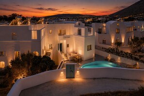 Um hotel moderno com piscina, área de estar ao ar livre e vista para o pôr do sol.