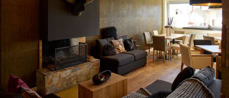 A modern living room with a fireplace, a stone accent wall, and a dining area with natural light.