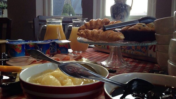 A breakfast table with croissants, juice, yogurt, and a bowl of fruit. - The Old Rectory Inn (Callander)