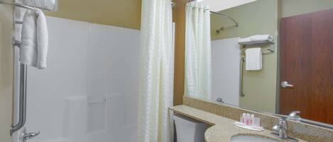 A bathroom with a bathtub, toilet, sink, and a mirror.