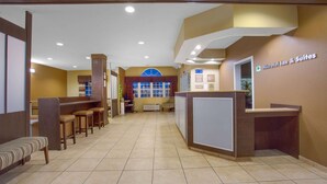 A reception area with a counter, seating, and a large window. - Microtel Inn & Suites by Wyndham Harrisonburg (Harrisonburg)