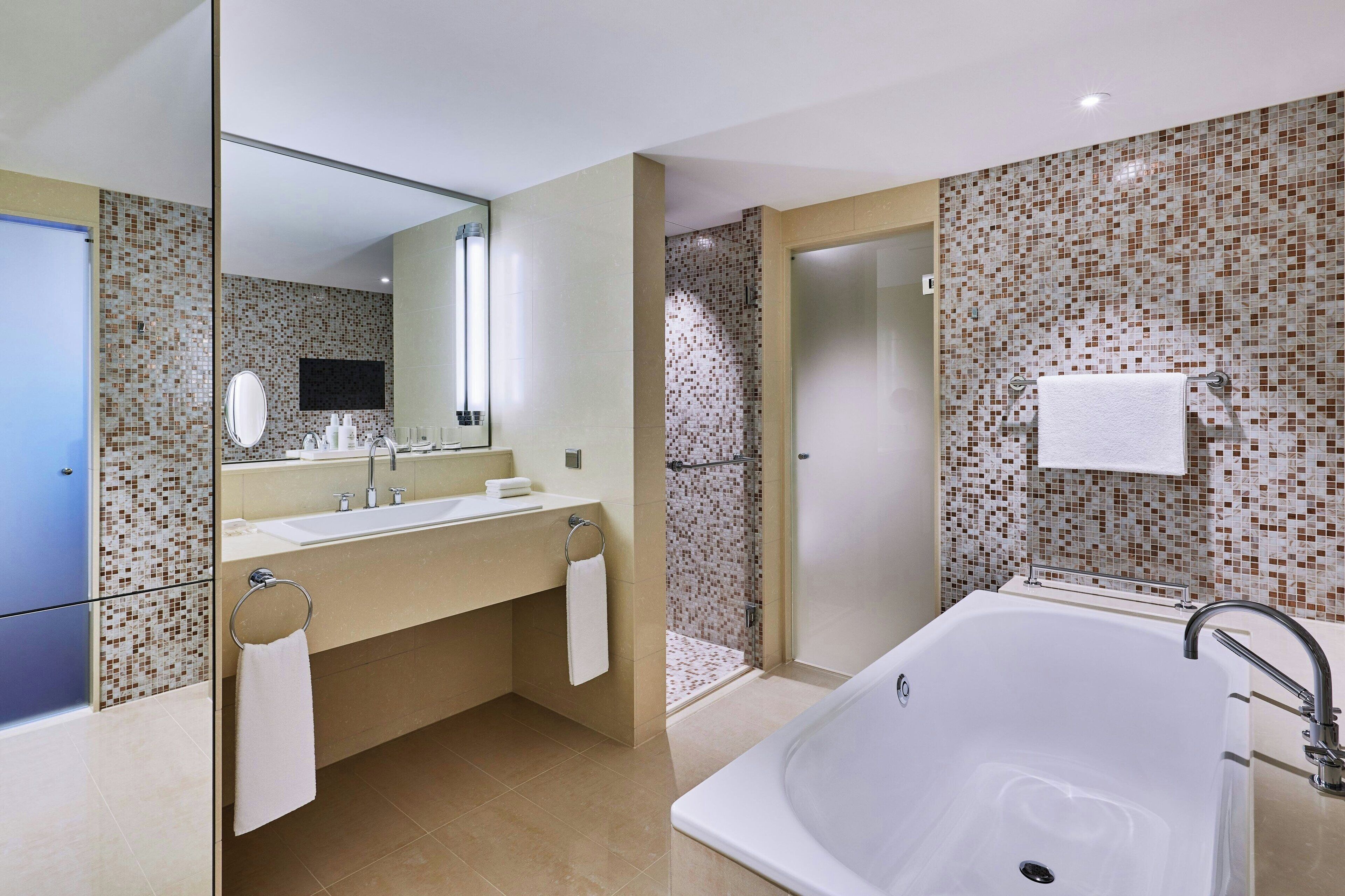 A modern bathroom with a large bathtub, a double sink vanity, and a shower area.