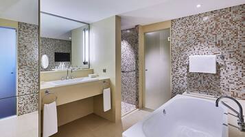 A modern bathroom with a large bathtub, a double sink vanity, and a shower area.