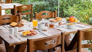 A breakfast setting with a table set for two, featuring croissants, toast, fruit, and a bowl of cereal. - Aeolis (Samos)