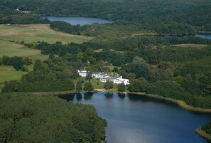A large estate with multiple buildings surrounded by dense forests and a lake. - Seehotel Luisenhof (Falkenhagen)
